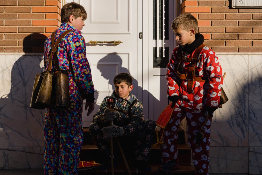 Unos niños vestidos de diablos descansan unos minutos antes de continuar danzando y saltando por el pueblo | Foto: Pedro Pascual