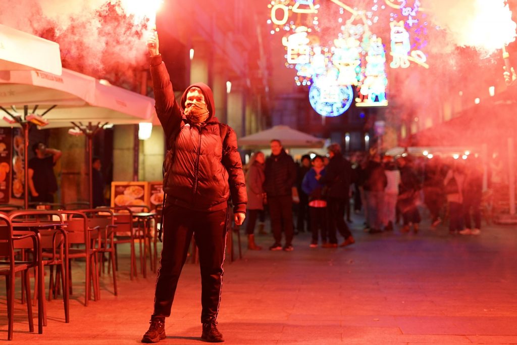 Joven con bengala en manifestación comunista