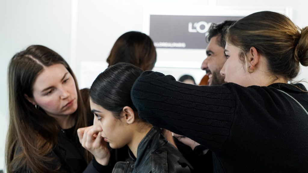 Una maquilladora y una peluquera preparan a una de las modelos para el desfile. | Foto: Chenoa Aguilar
