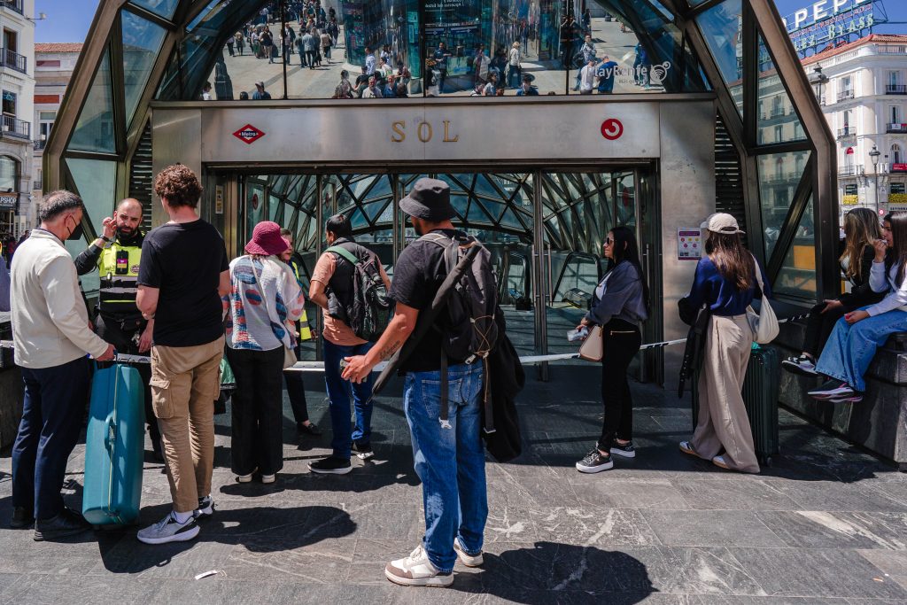 Algunos pasajeros esperan en la entrada de la estación de metro de Sol | Foto: Pedro Pascual 
