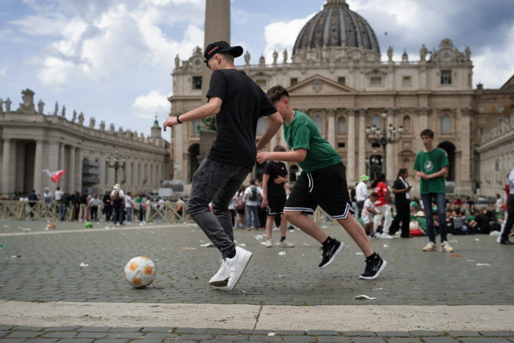 Varios jóvenes juegan al fútbol en la plaza de San Pedro al terminar la segunda misa Novendial por el Santo Padre papa Francisco, el 27 de abril de 2025 | Foto: Marcos Villaoslada